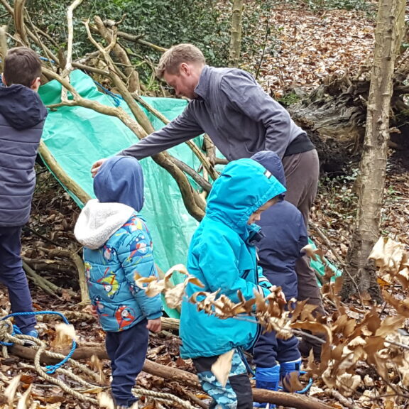 Children den-making in the woods