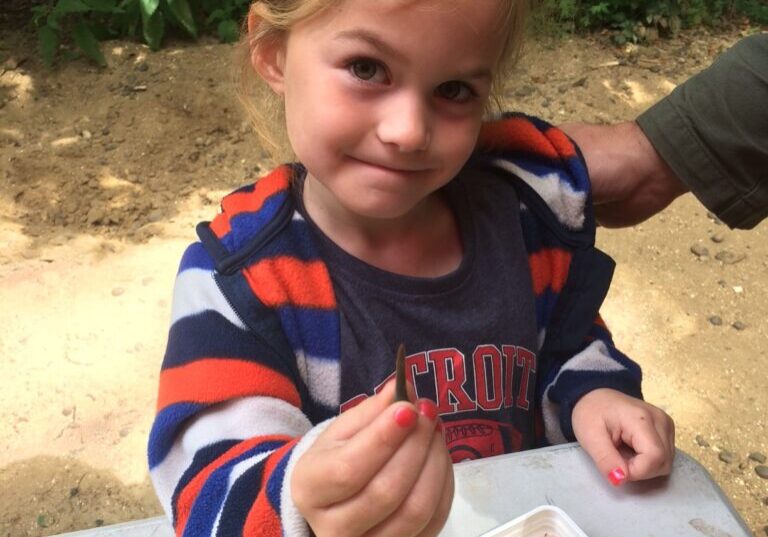 Girl holding a shark's tooth fossil