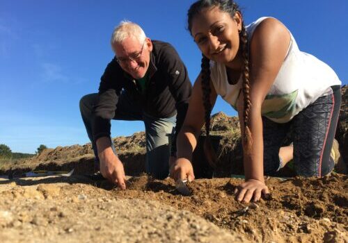 Man and girl in a archaeological dig trench digging
