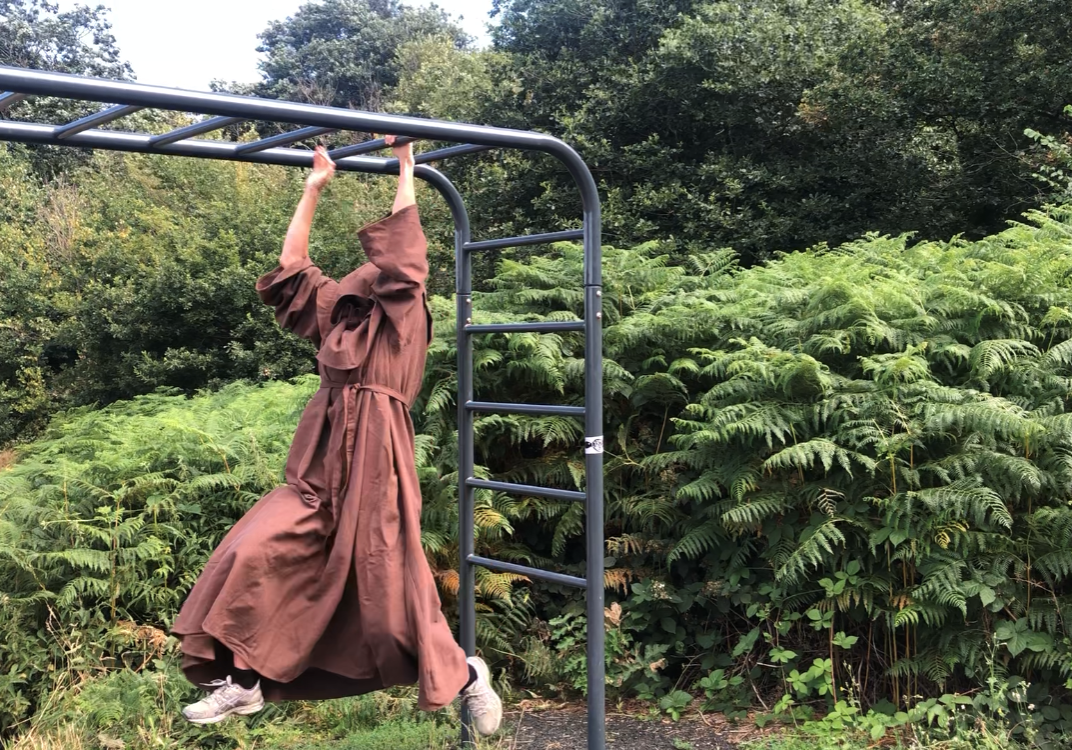 A man dressed as a monk using the trim trail
